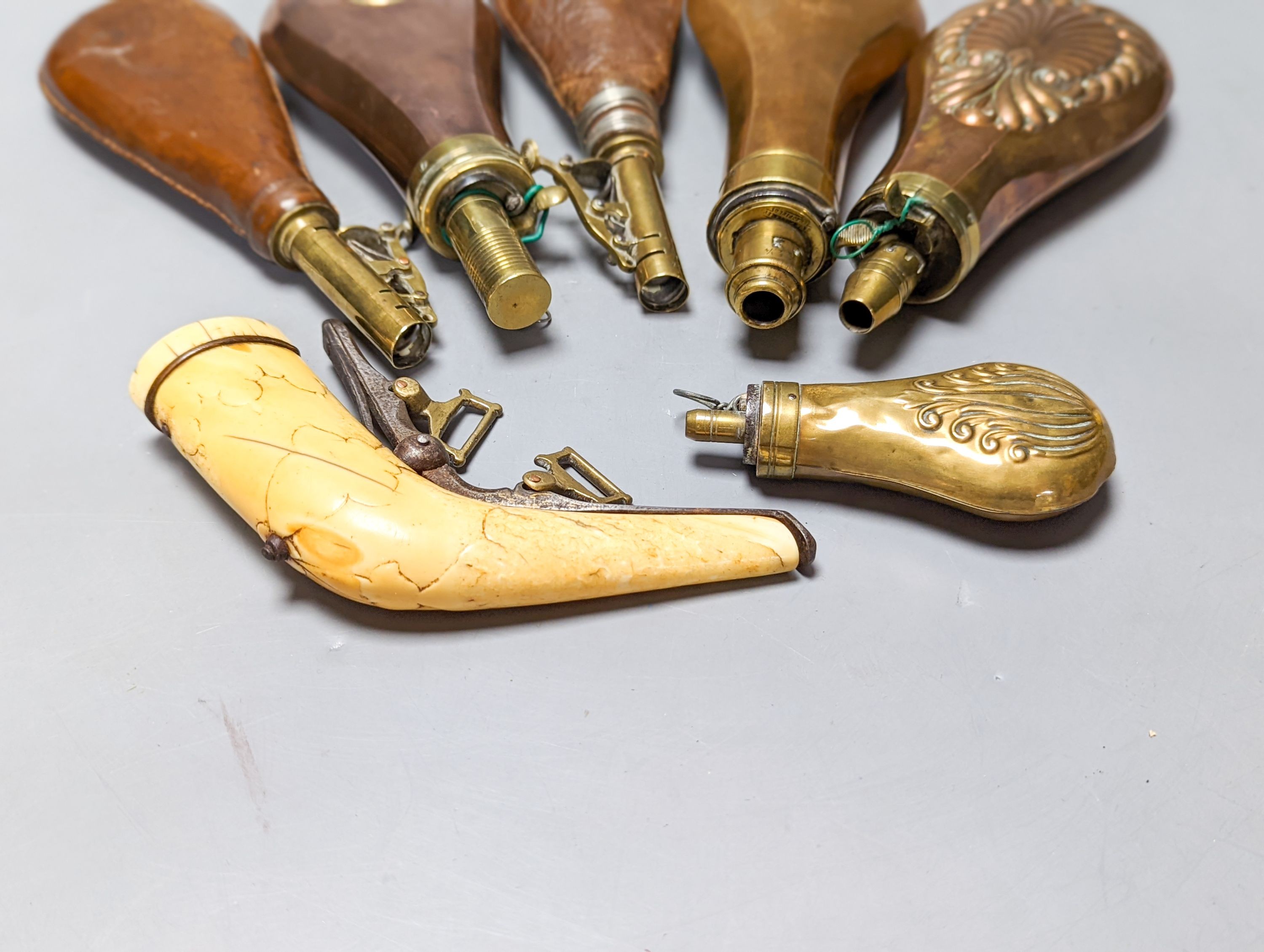 Six powder/shot flasks, 4 copper and brass, 2 leather and brass, together with a carved powder horn (7)